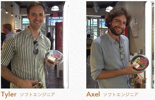 写真：手にアヒポケ丼を持っているTyler （ソフトエンジニア）と、同じくアヒポケ丼を持つAxel（ソフトエンジニア）