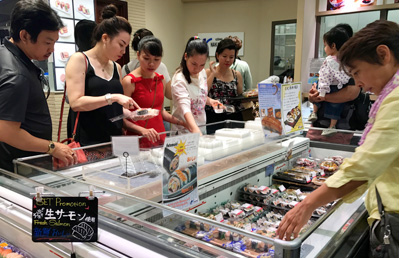 写真：たくさんのお客さんがテイクアウトのお寿司を選んでいる