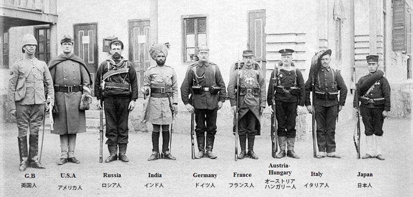 写真：当時の軍服を着た、英国人、アメリカ人、ロシア人、インド人、ドイツ人、フランス人、オーストリアハンガリー人、イタリア人、日本人の軍人が一列に並んでいる。